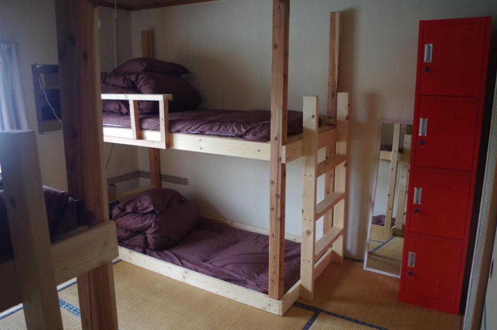 a room with two bunk beds in a room at Kusatsu Onsen Guesthouse Gyoten in Kusatsu
