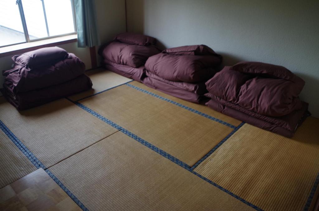 a room with three bean bags sitting on the floor at Kusatsu Onsen Guesthouse Gyoten in Kusatsu