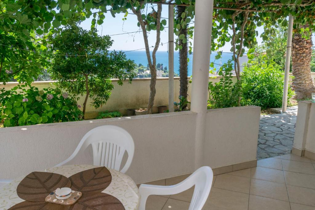 a table and chairs on a patio with a view of the ocean at Apartments Aleksandar in Ulcinj