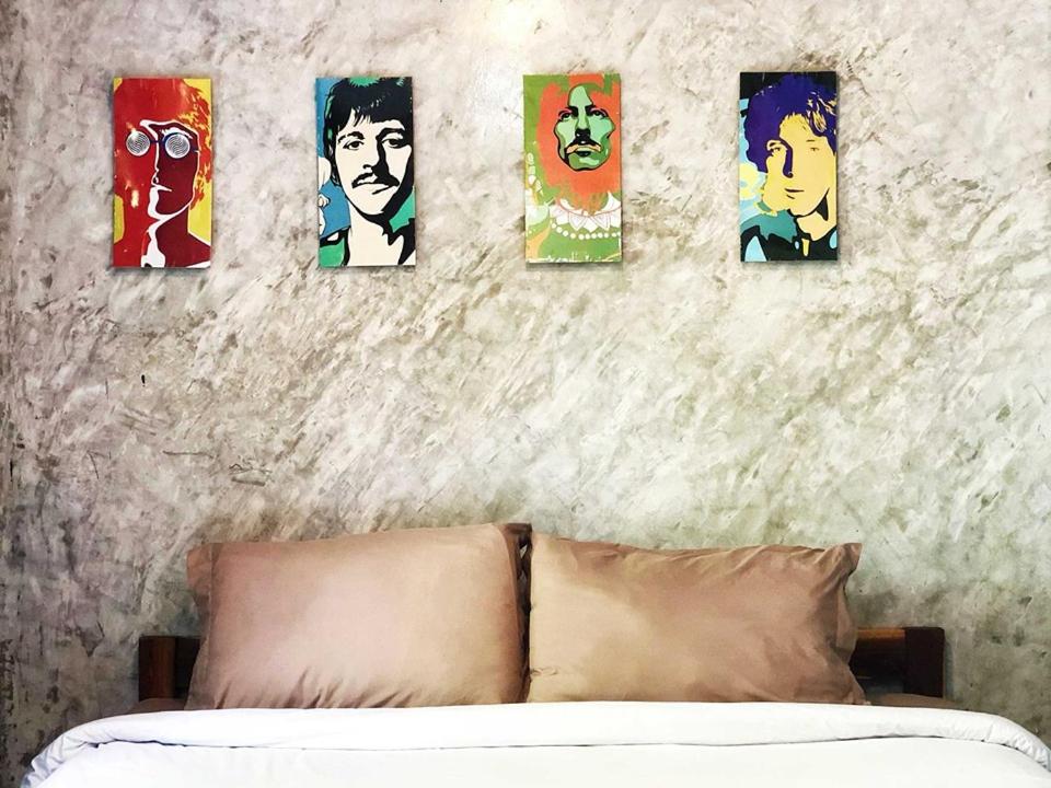 una camera da letto con 4 immagini appese al muro sopra un letto di เชอโคว์ เชอโคว์ โฮมสเตย์ a Sangkhla Buri