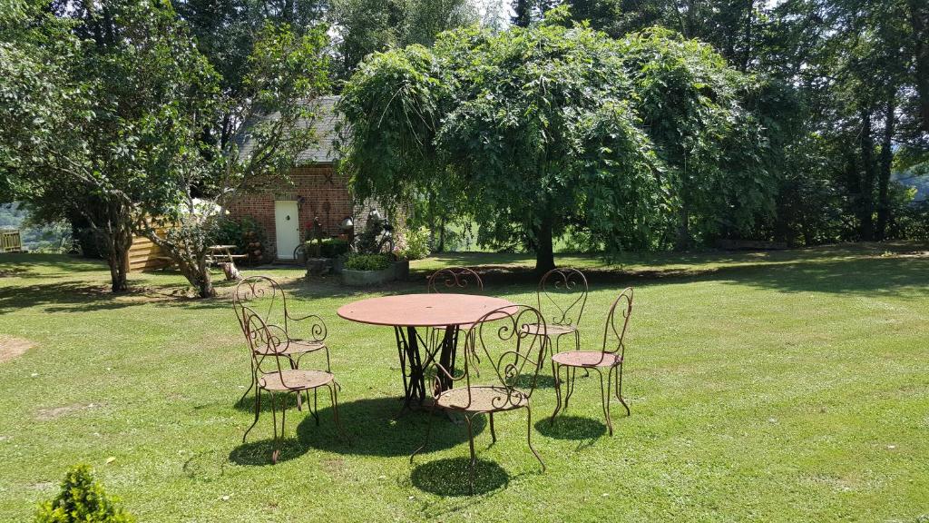 einen Tisch und Stühle auf einem Hof in der Unterkunft ANNEXE DU PARC 1 in Vimoutiers