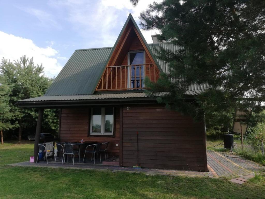 a small house with a deck and a table at DOMEK ROZTOCZE in Zwierzyniec