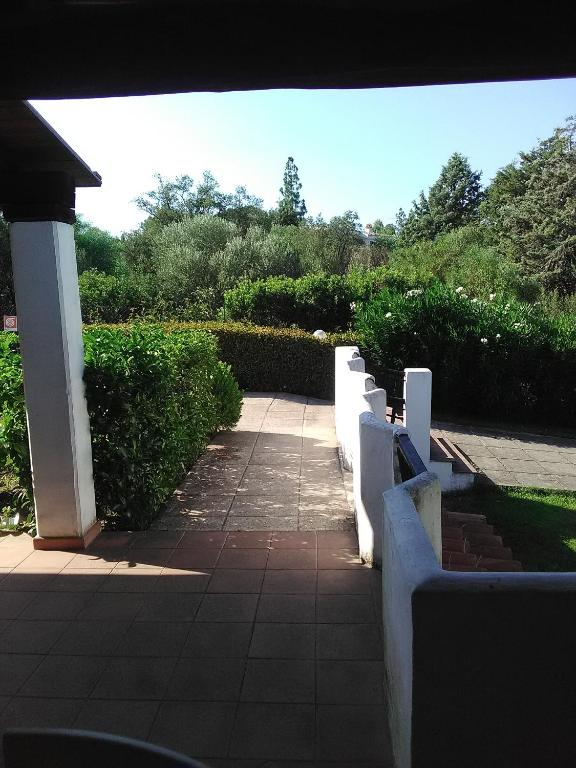 a walkway with white fences and a sidewalk at White Sand Residence in Murta Maria
