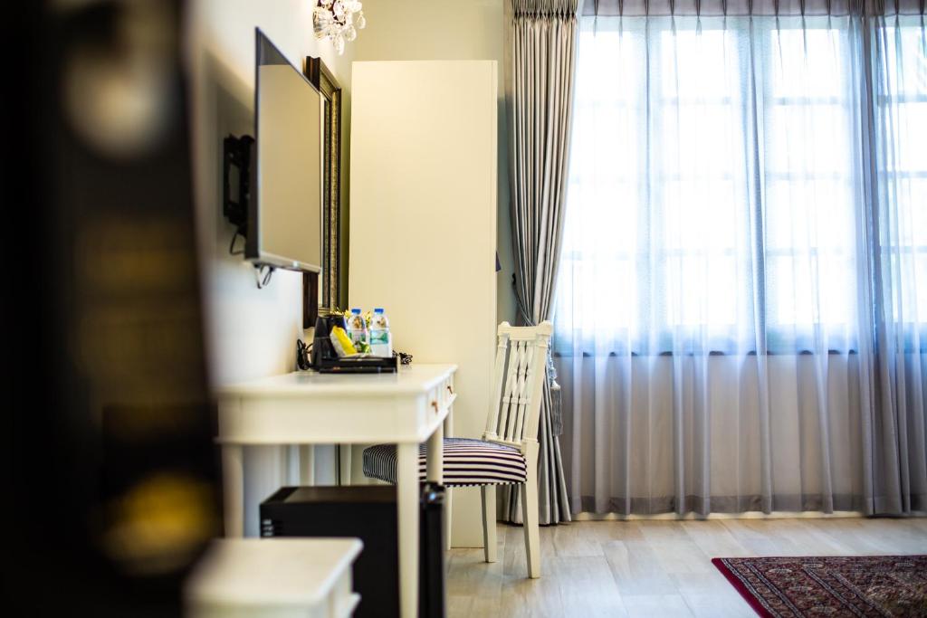 A compact in-room desk sits beside a curtained window.