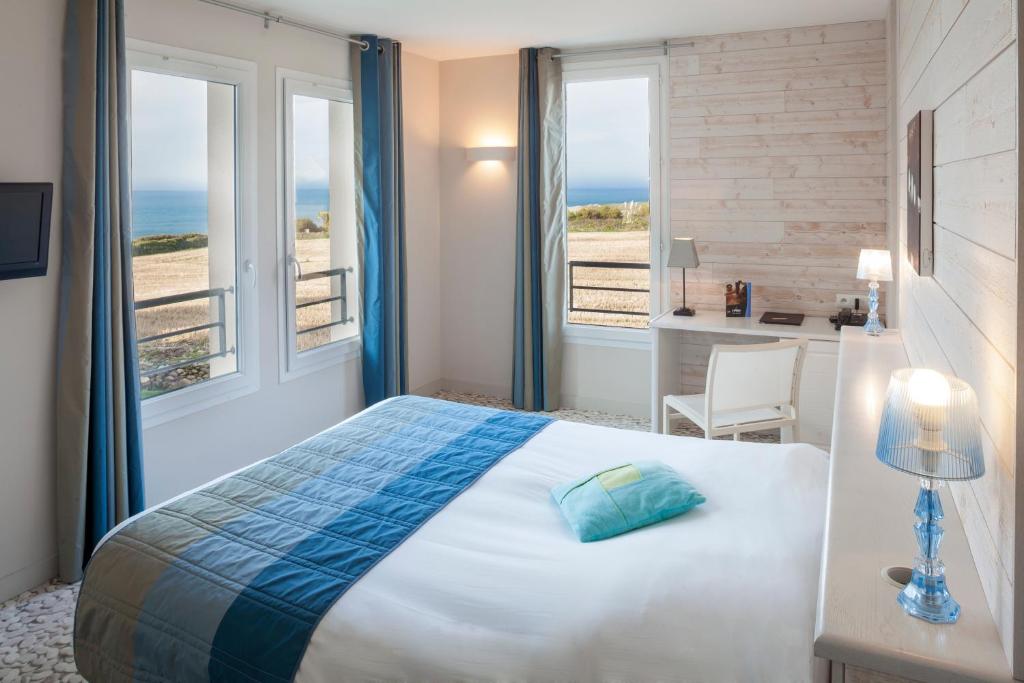 een slaapkamer met een bed en uitzicht op de oceaan bij Logis Hôtel Vent d'Iroise in Plougonvelin