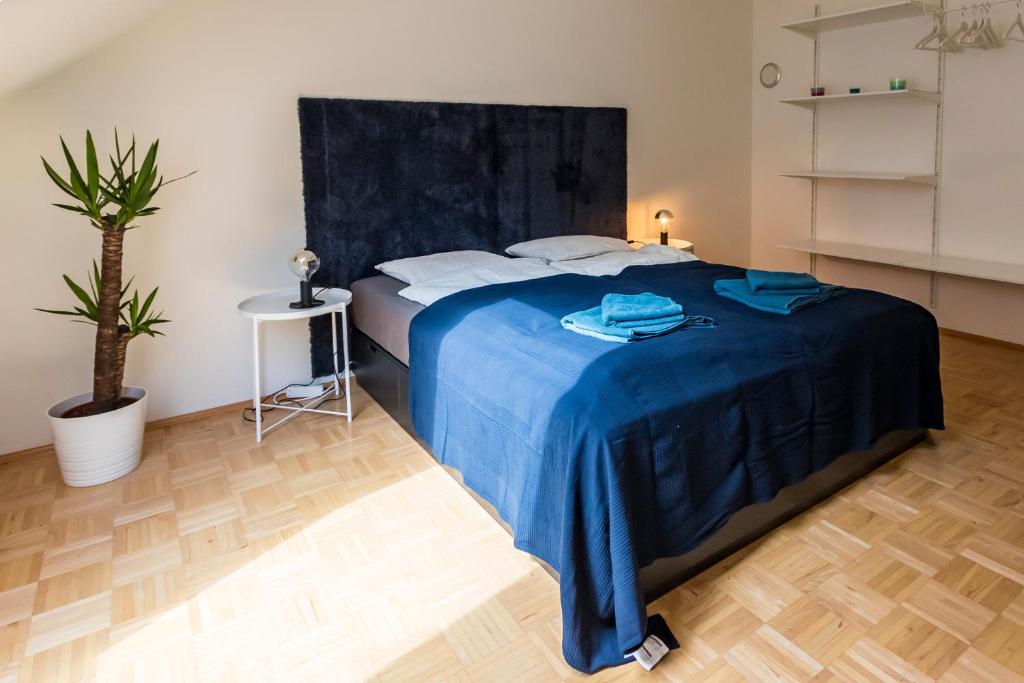 a bedroom with a bed with a blue blanket at Flataid Apartment Obere Bahnstraße - Grazer Messe in Graz