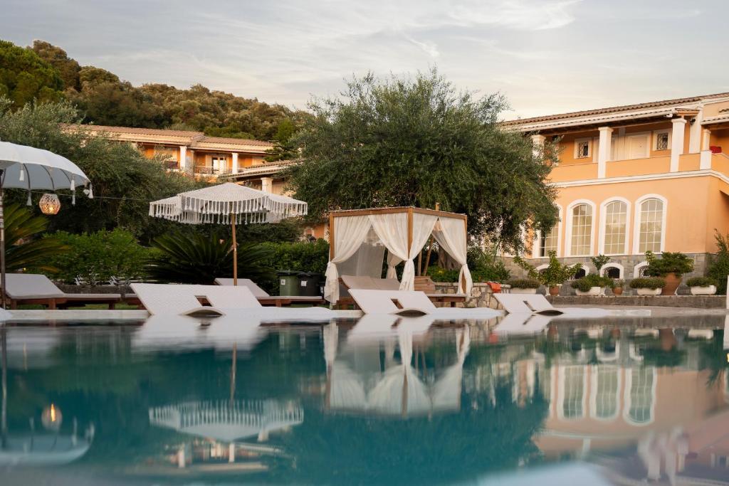 a hotel swimming pool with chairs and a tent at Nefeli Hotel in Kommeno