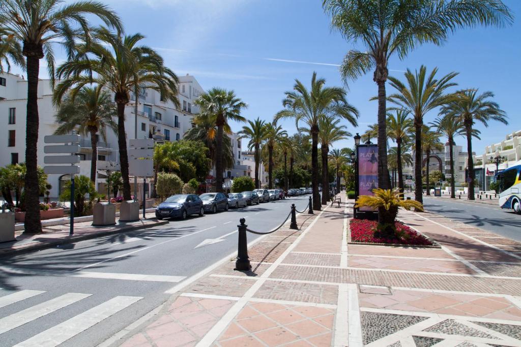 a city street with palm trees and a crosswalk at Puerto Banus Jardines del Puerto Apartment for up to 6 Gardens, pools, garage, wifi, terrace in Marbella