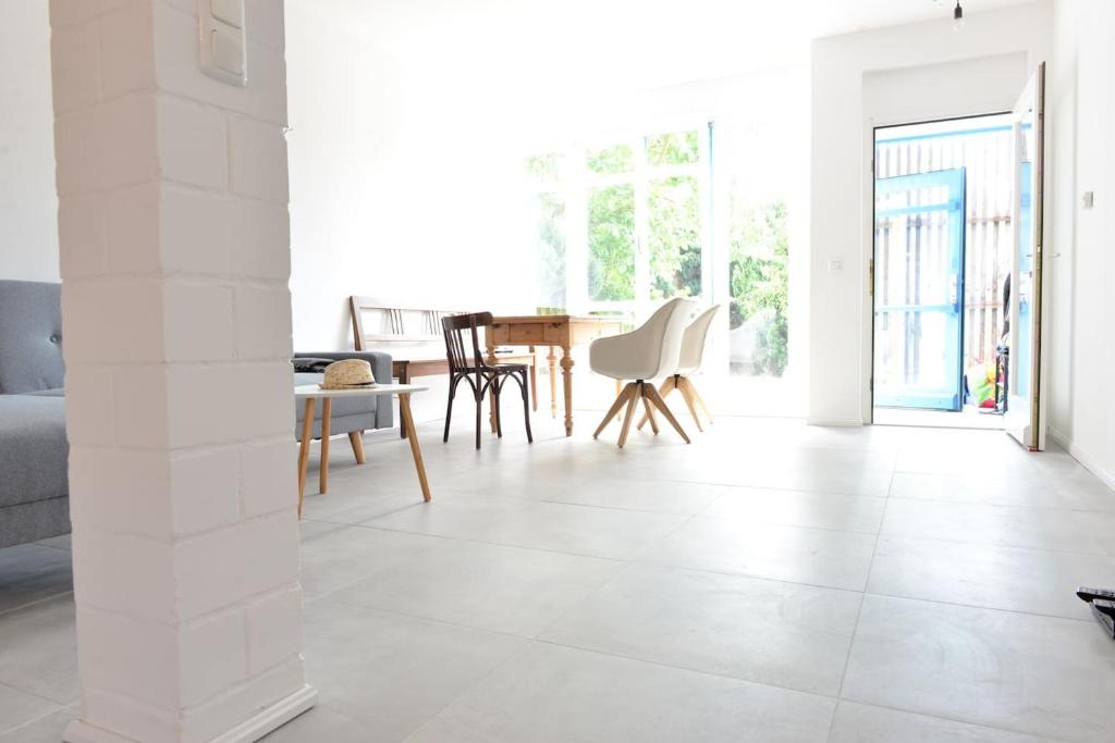 a living room with white tile flooring and a table and chairs at 3FLOORS in Rankwitz