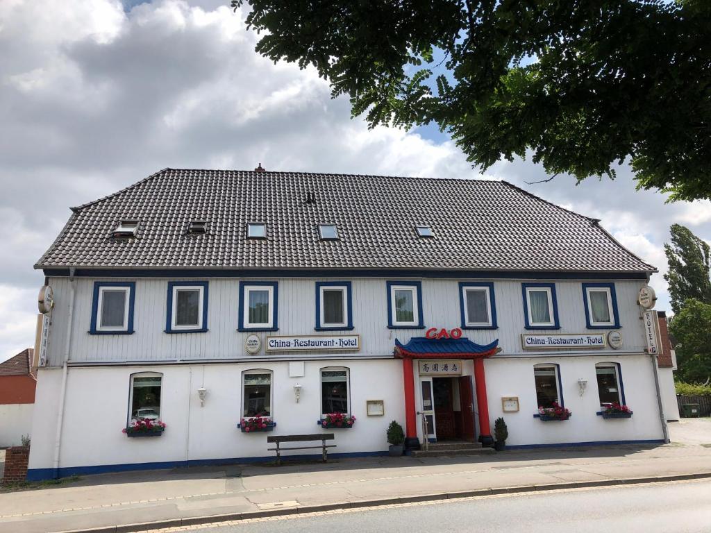 a white building with a black roof at Hotel Cao in Hemmingen