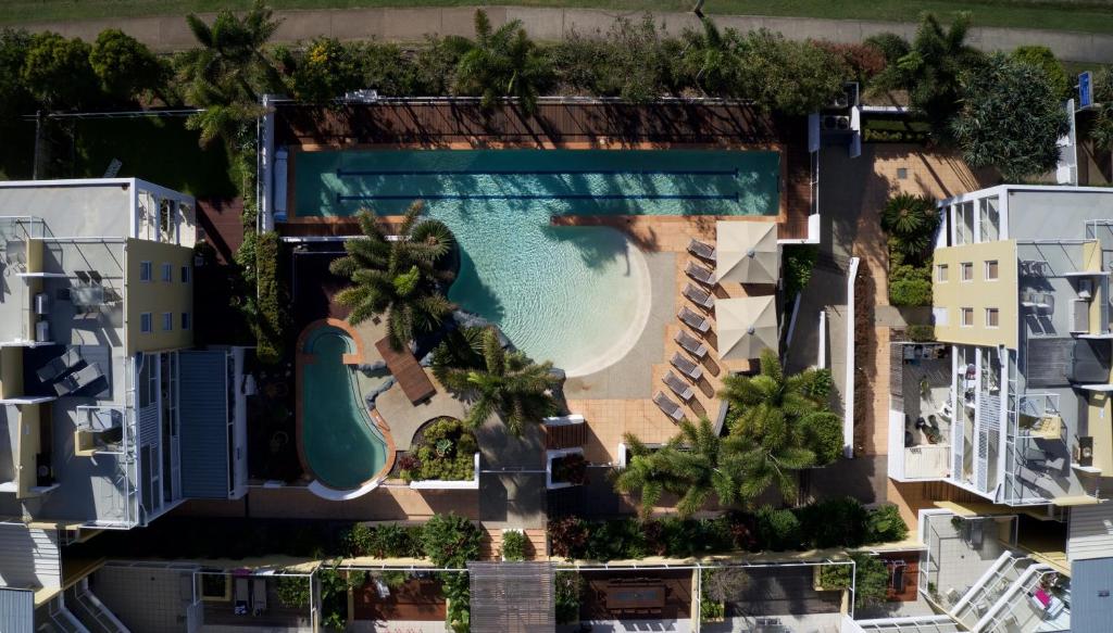una vista aérea de una piscina con palmeras y casas en Seachange Coolum Beach, en Coolum Beach