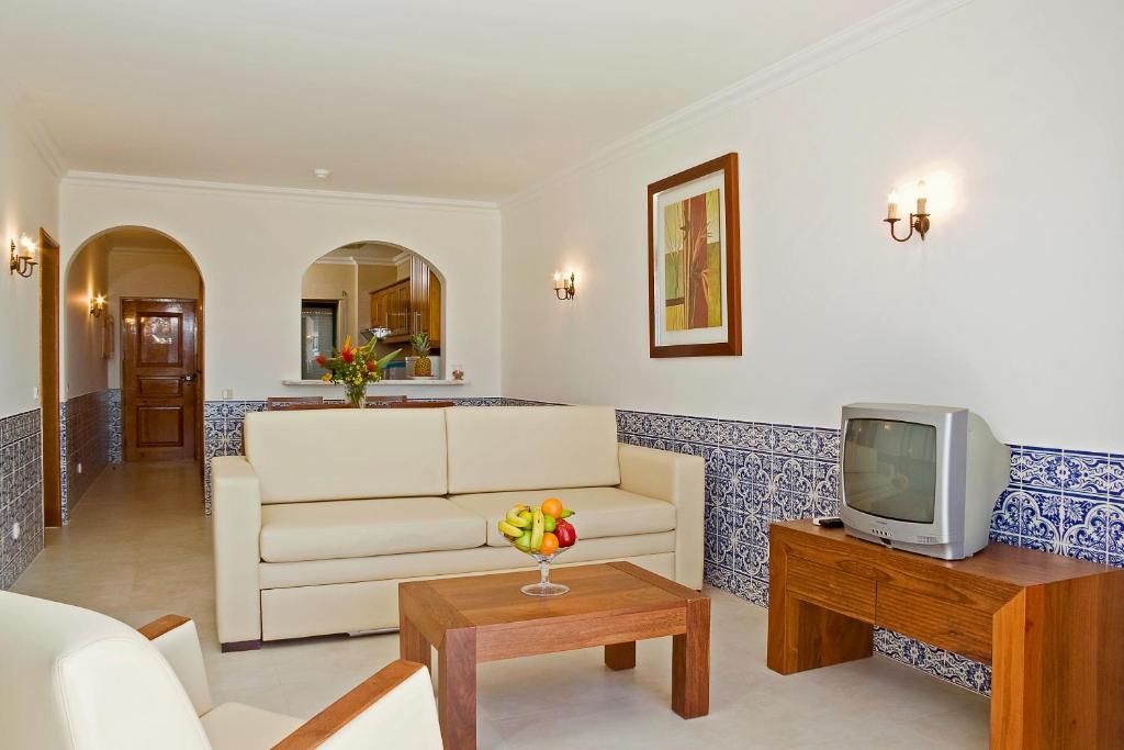 a living room with a white couch and a tv at Cerro Mar Atlantico & Cerro Mar Garden in Albufeira