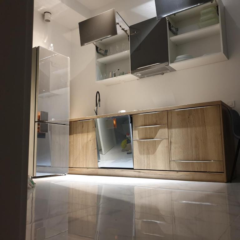an empty kitchen with wooden cabinets and a sink at LUKA in Budva