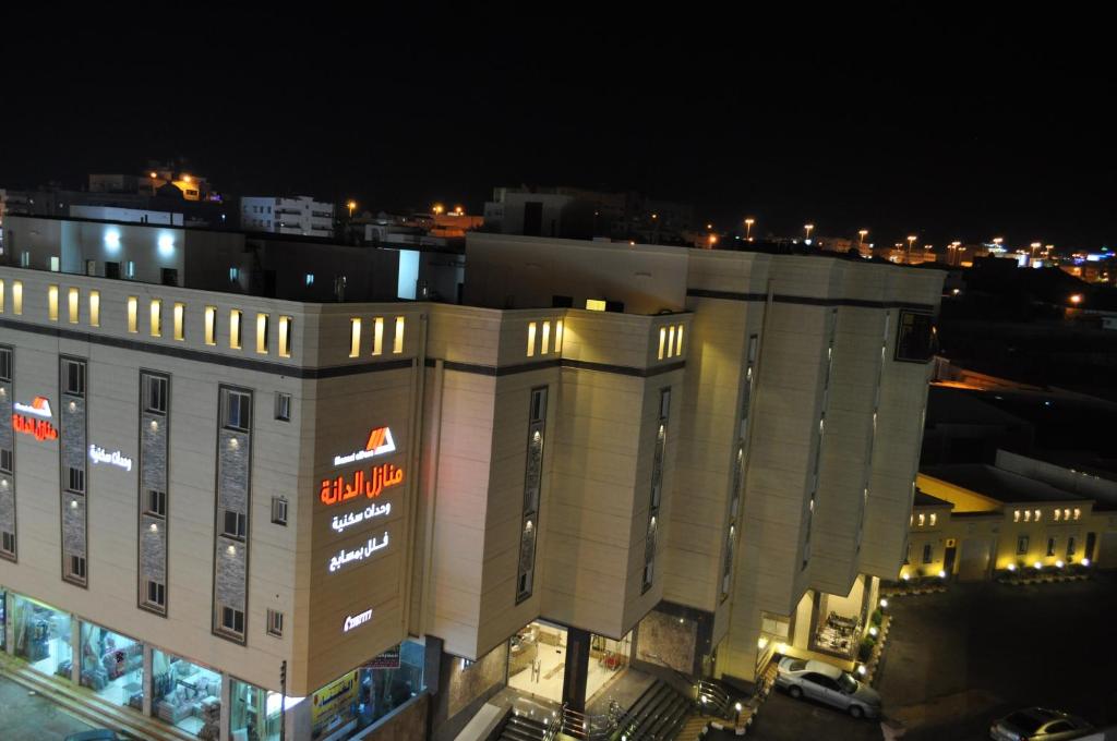 duży budynek z znakiem na nim w nocy w obiekcie Manazel Aldana w mieście Abha