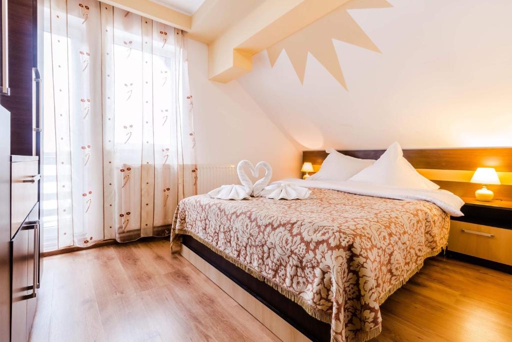 a bedroom with a bed and a large window at Pensiunea Dorali in Moieciu de Jos