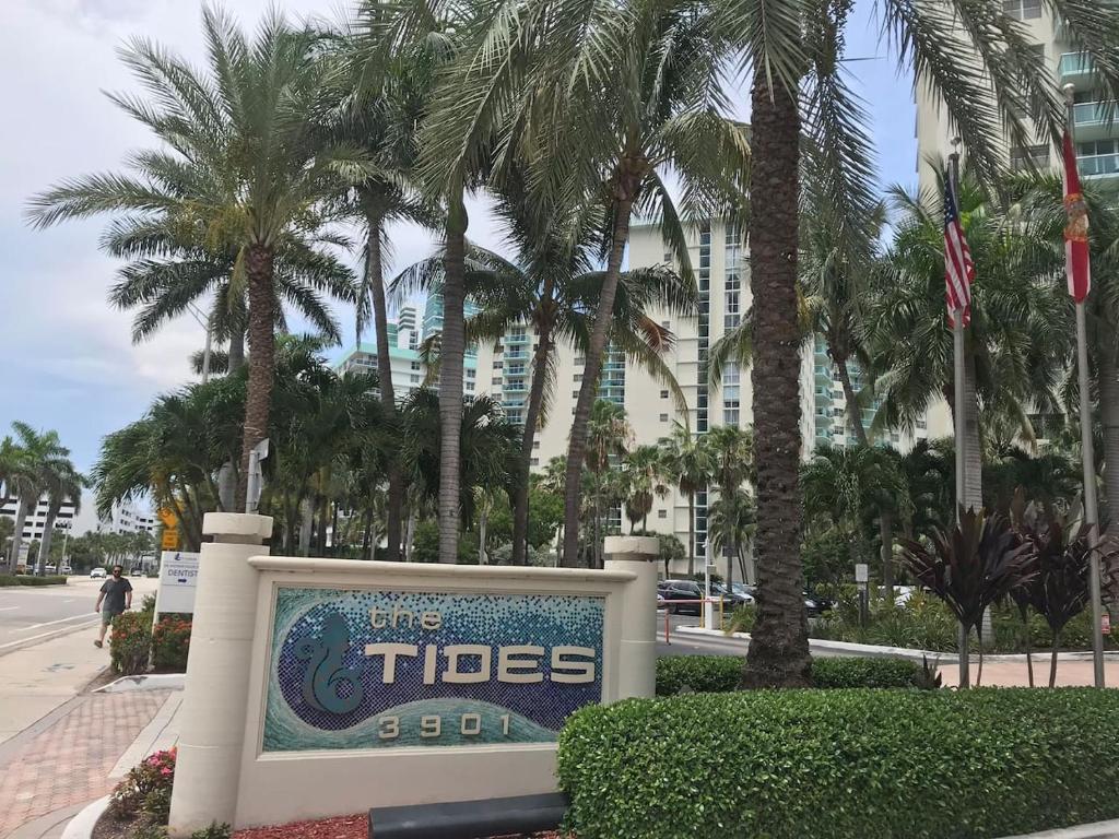 una señal frente a un edificio con palmeras en The Thides en Hollywood
