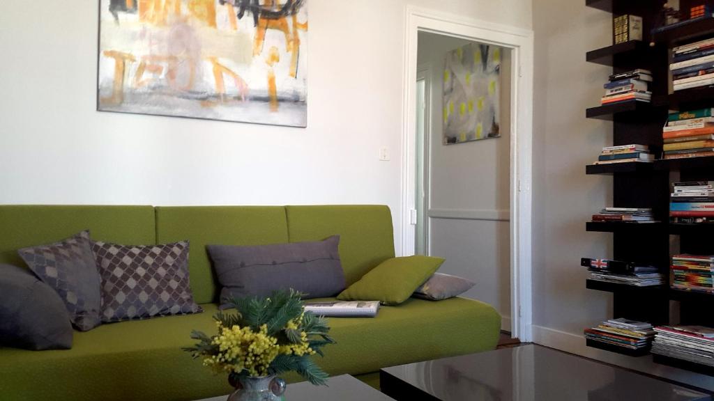 a living room with a green couch and a table at Le gîte de l&#39;atelier in Bergerac