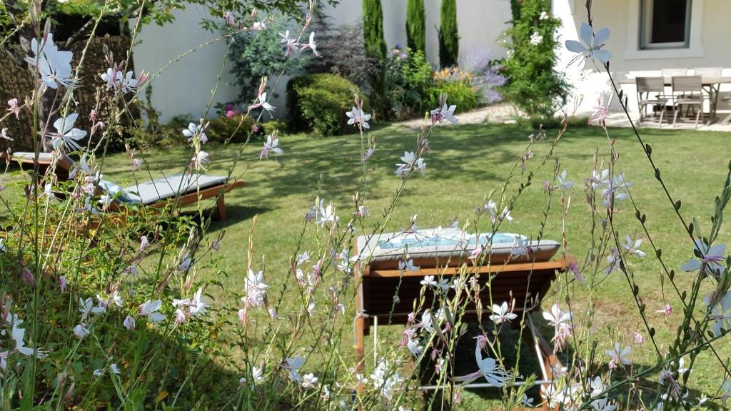 a garden with two benches in the grass at Le gîte de l&#39;atelier in Bergerac
