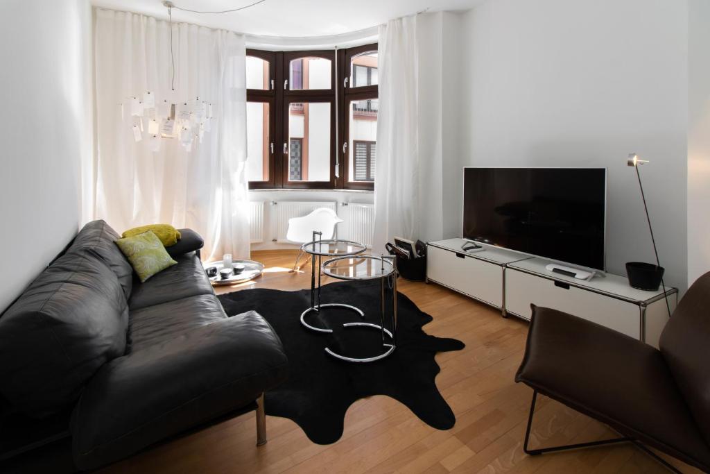 ein Wohnzimmer mit einem Sofa und einem TV in der Unterkunft Casa Augusta - Urban Living in Trier