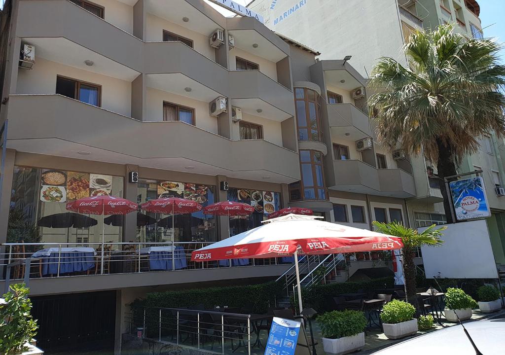 un paraguas rojo frente a un edificio en Hotel Palma, en Durrës