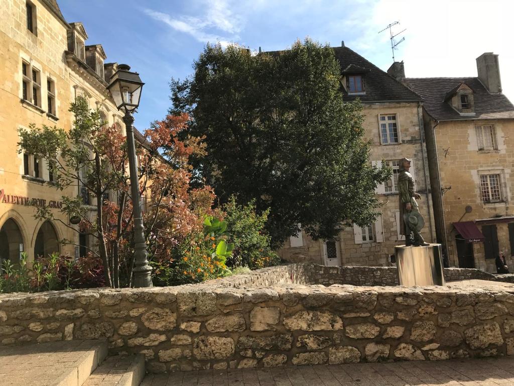 a stone wall in front of some buildings at Le gîte de l&#39;atelier in Bergerac