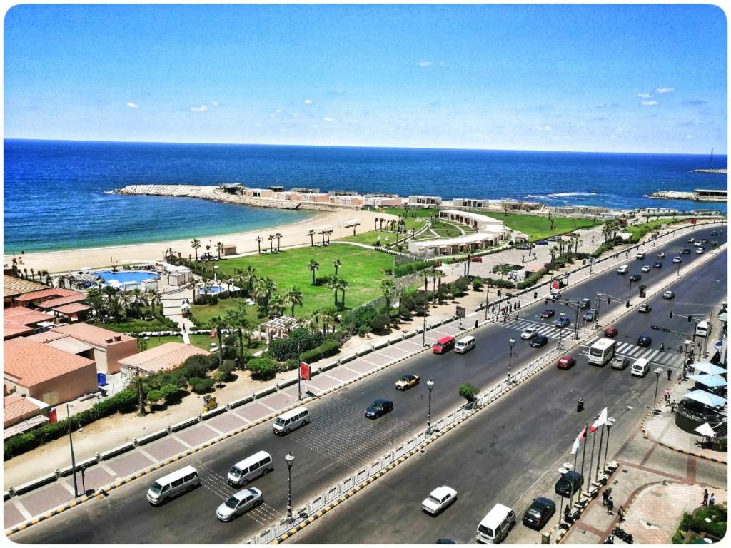 a busy street with cars on a road next to the ocean at San Stefano apartment on the sea in Alexandria