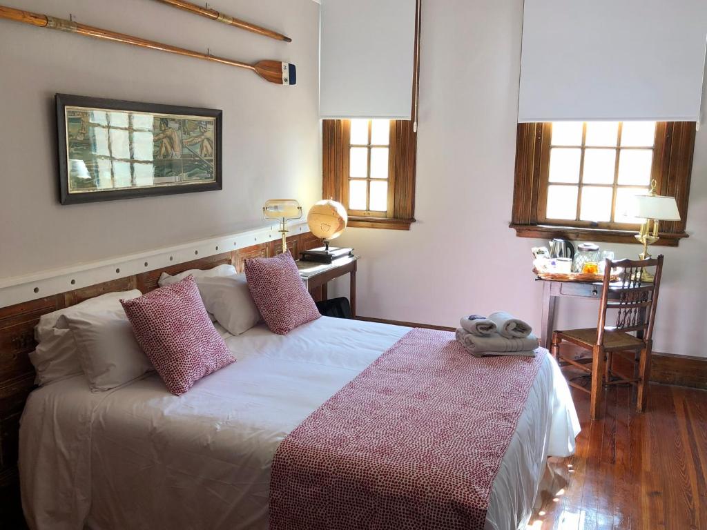 a bedroom with a bed and a table and windows at Buenos Aires Rowing Club in Tigre