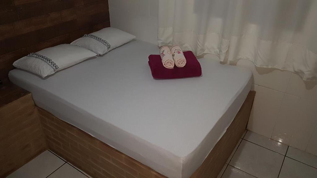 a small bed with a pair of shoes on it at Pouso in Pirenópolis