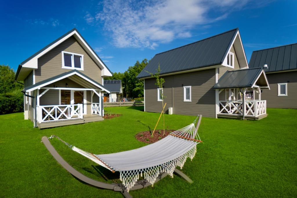 a hammock in front of a house at Kompleks Wypoczynkowy Bryza III in Lubiatowo