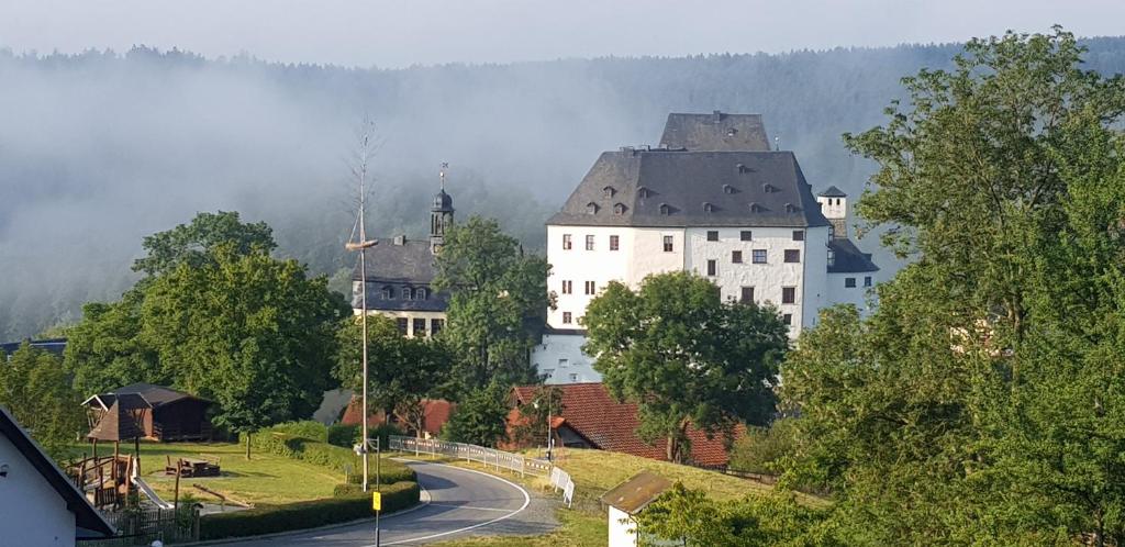 ein großes weißes Gebäude an der Seite einer Straße in der Unterkunft Ferienwohnung Schloss Burgk in Burgk