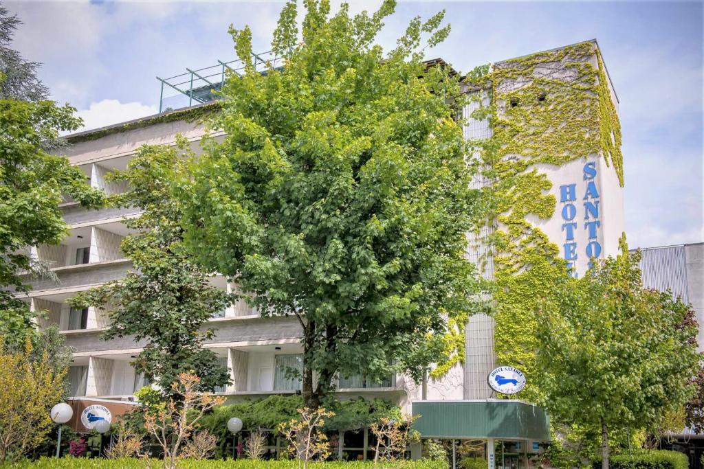 un edificio con un albero di fronte di Hotel Santoli a Porretta Terme