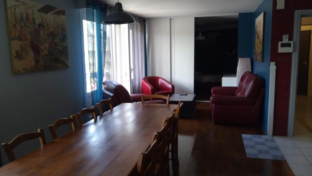 Cette chambre comprend une grande table et des chaises en bois. dans l'établissement Hôtel Patton, à Avranches