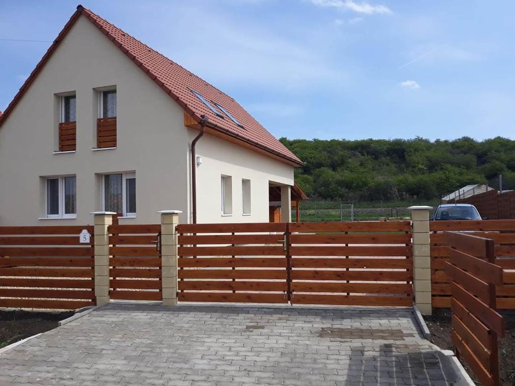 a wooden fence in front of a house at TERMÁLKINCS Vendégház in Demjén