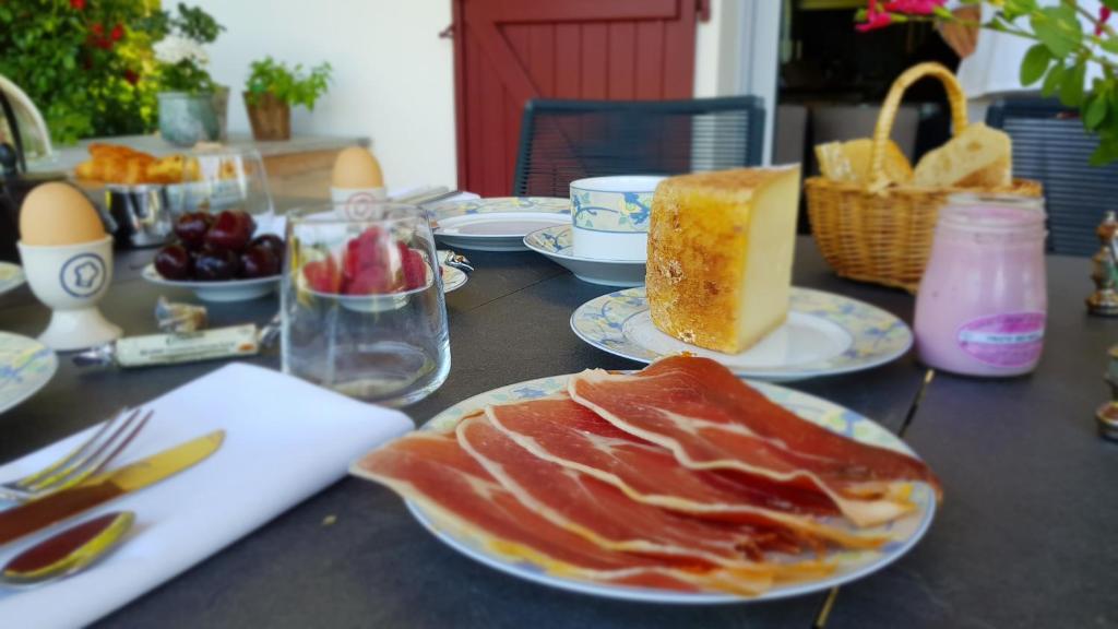 a table with plates of food on top at Maison d hotes Lapitxuri in Arcangues
