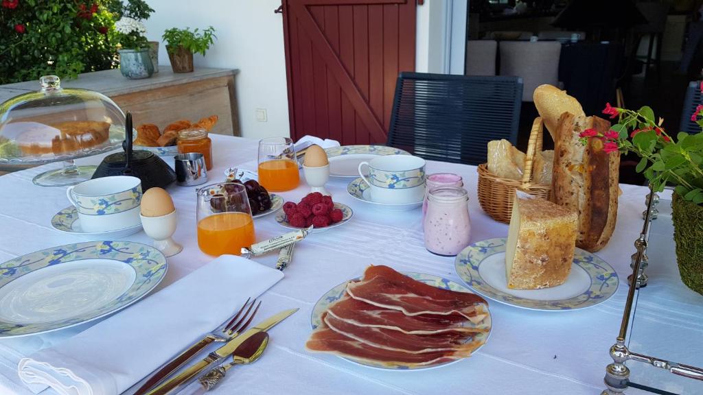 a table with plates of food and eggs and bread at Maison d hotes Lapitxuri in Arcangues