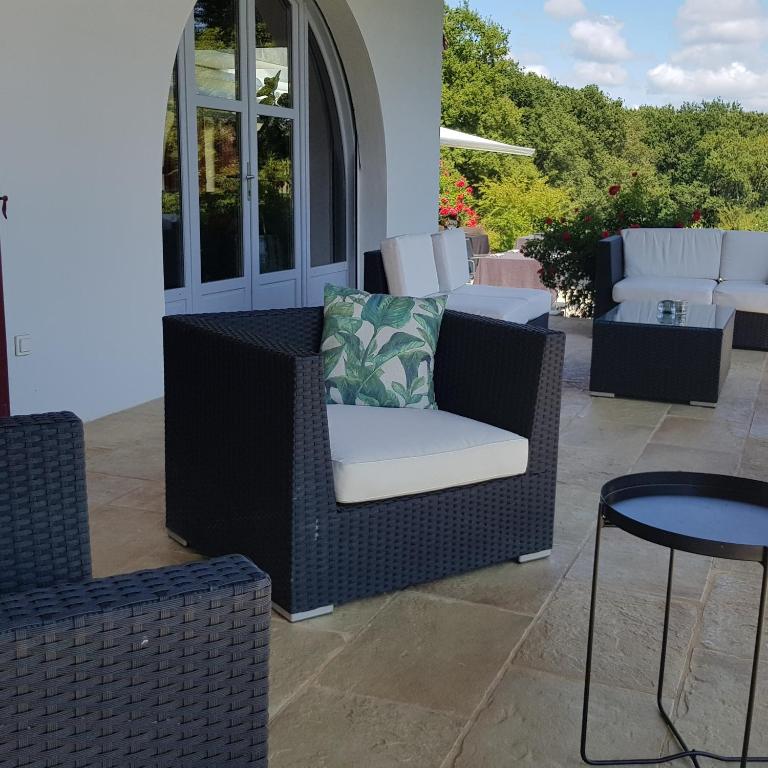 a wicker chair and table on a patio at Maison d hotes Lapitxuri in Arcangues