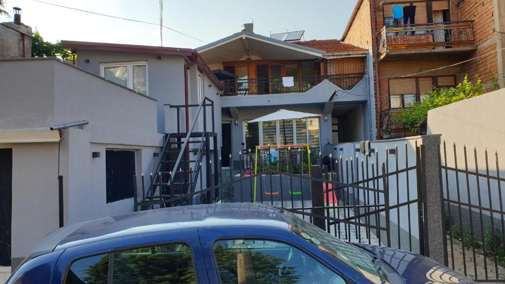 Niebieski samochód zaparkowany przed domem w obiekcie Majestic Rooms&Apartments w mieście Prilep