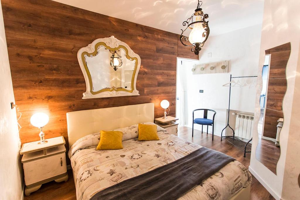 1 dormitorio con 1 cama grande y pared de madera en Relais Garibaldi, en Avezzano