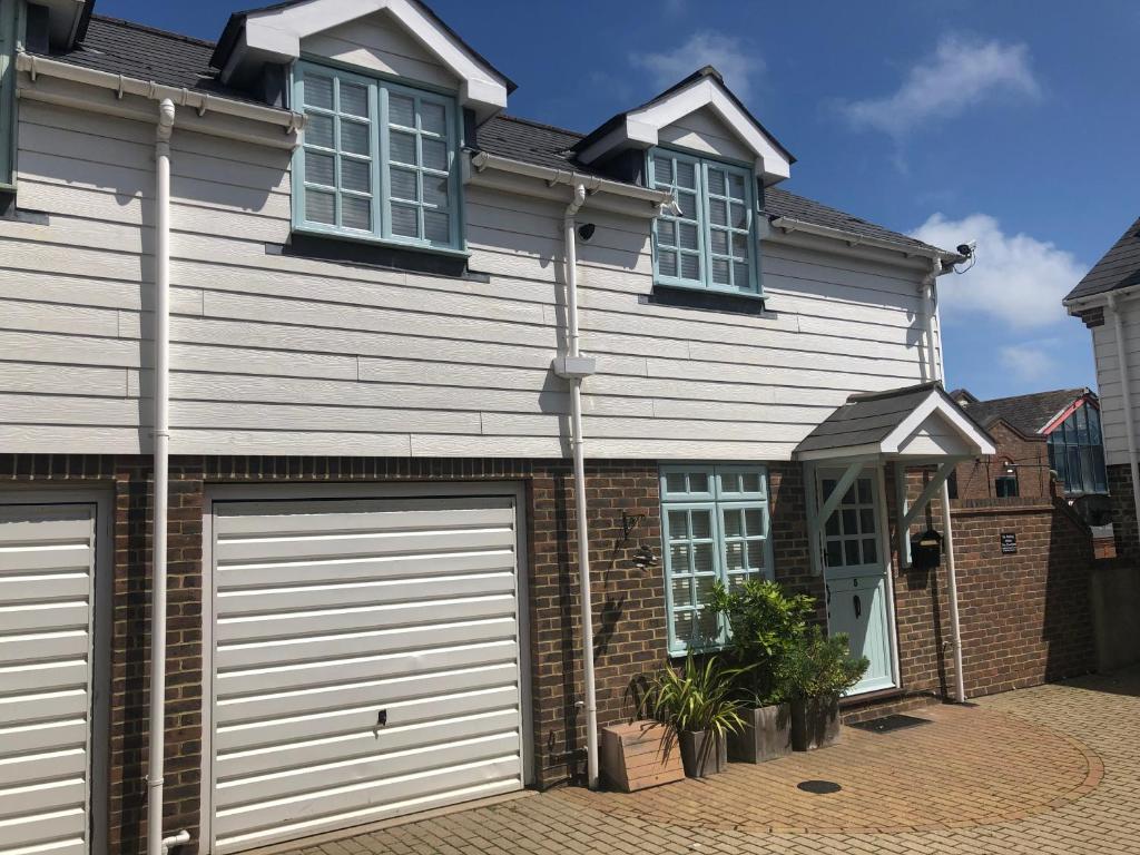 a house with two garage doors in front of it at Pixie Cottage in Eastbourne