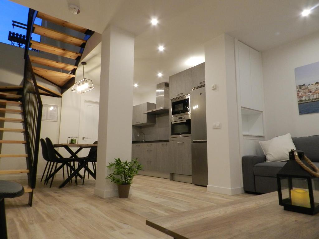 a kitchen and living room with a couch and a table at Tu Casa en Santander in Santander