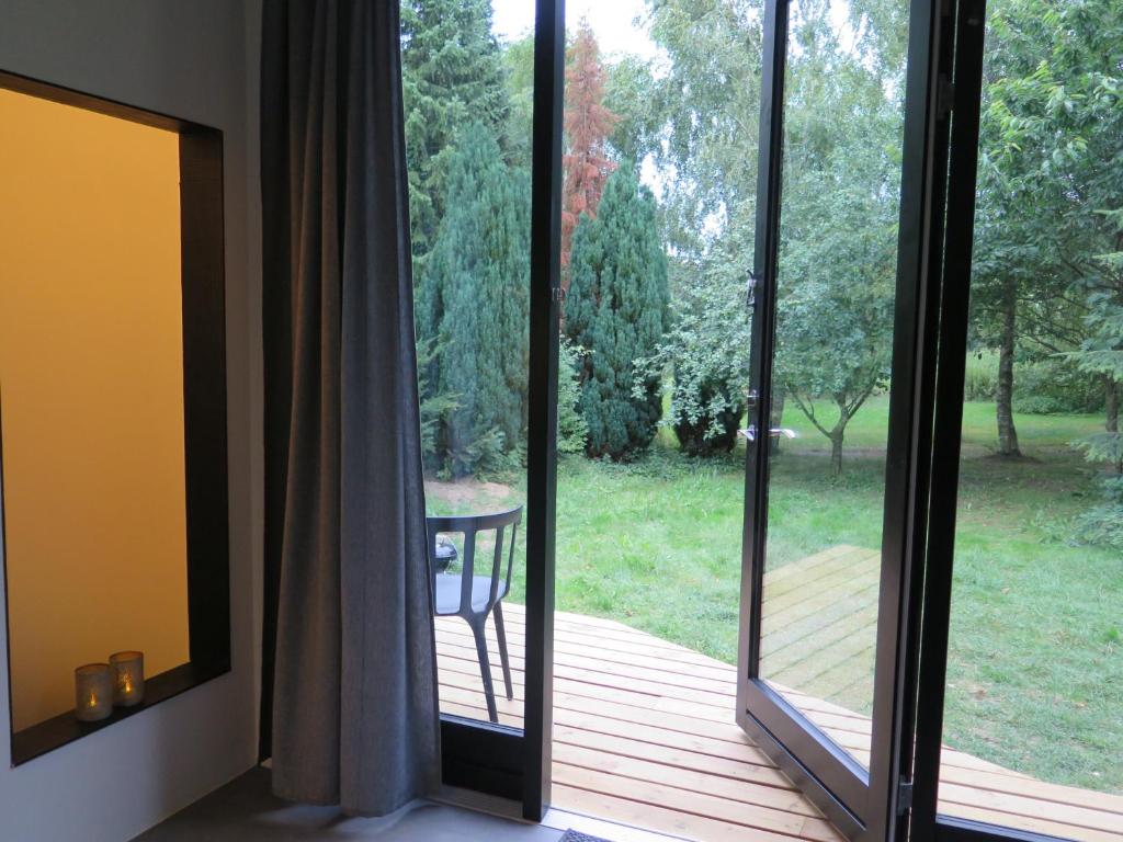 Zimmer mit Glasschiebetüren und Blick auf eine Terrasse in der Unterkunft Ferieidyl in Kettinge