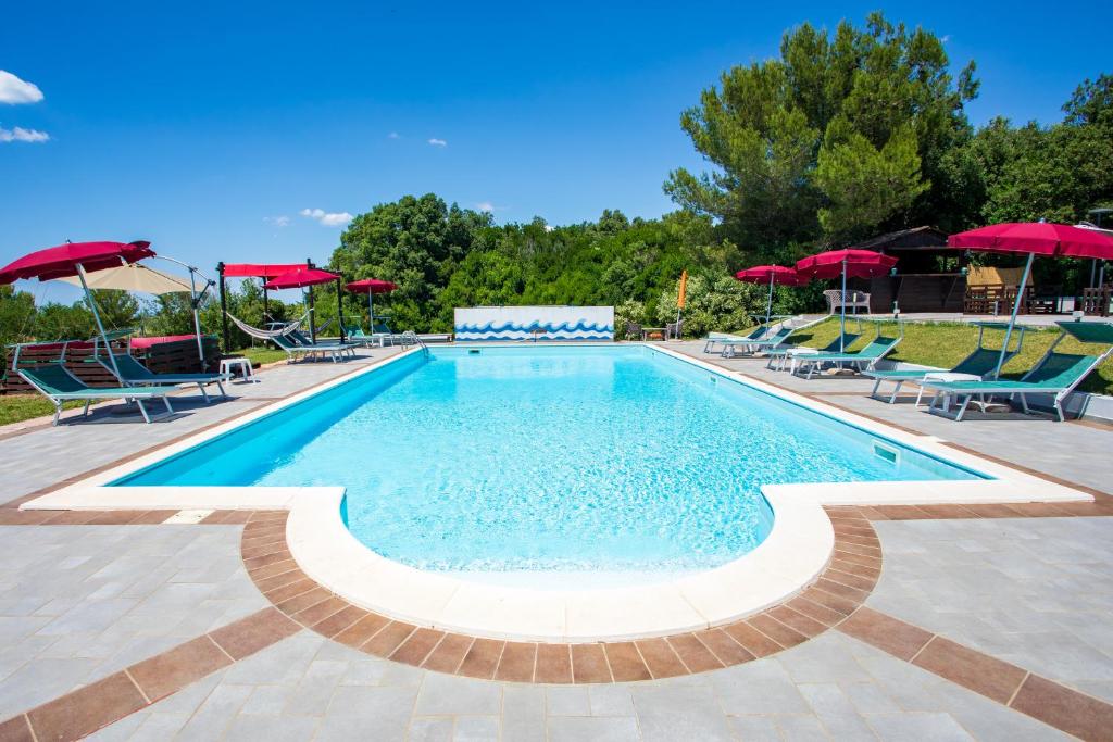 a large swimming pool with chairs and umbrellas at Villa Liburnia in Livorno
