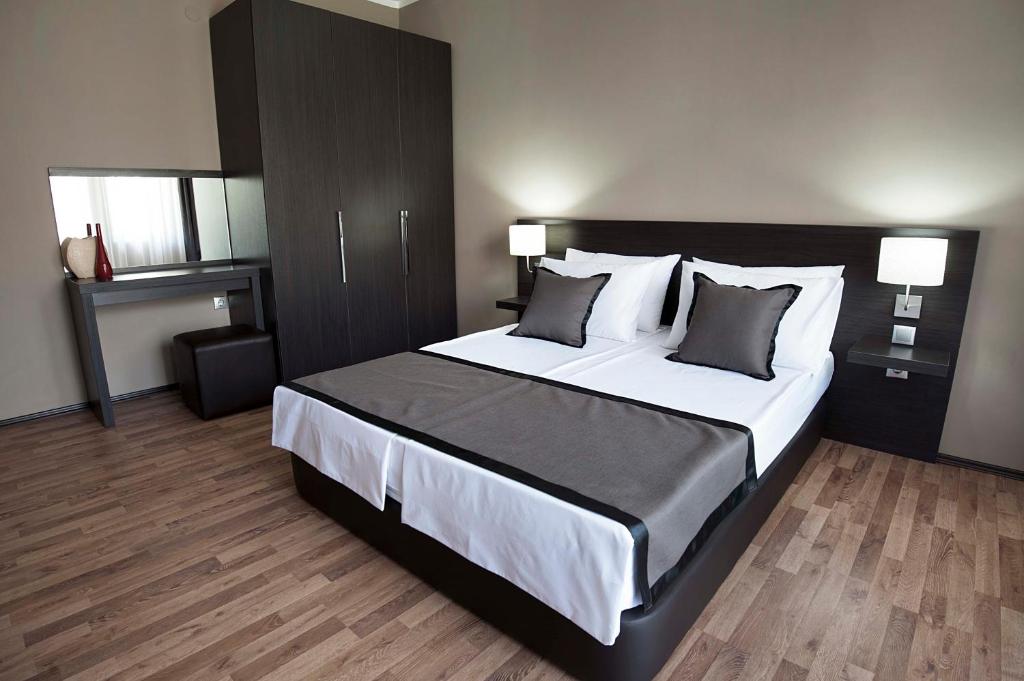 a bedroom with a large bed with white sheets and pillows at Soho Apartments in Bitola