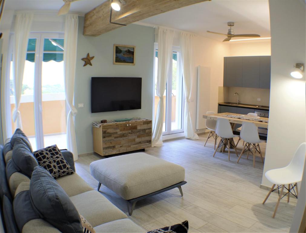 Una sala de estar con un sofá y un televisor de pantalla plana. en CaseMaggi Beach House Terrace, en Portovenere