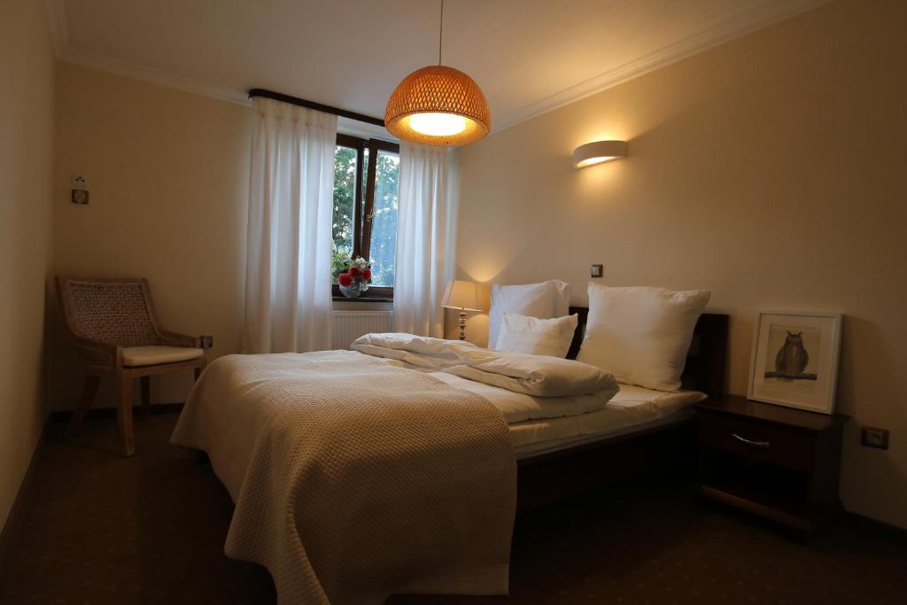 Schlafzimmer mit einem Bett mit weißer Bettwäsche und einem Fenster in der Unterkunft Villa Czarli in Misdroy