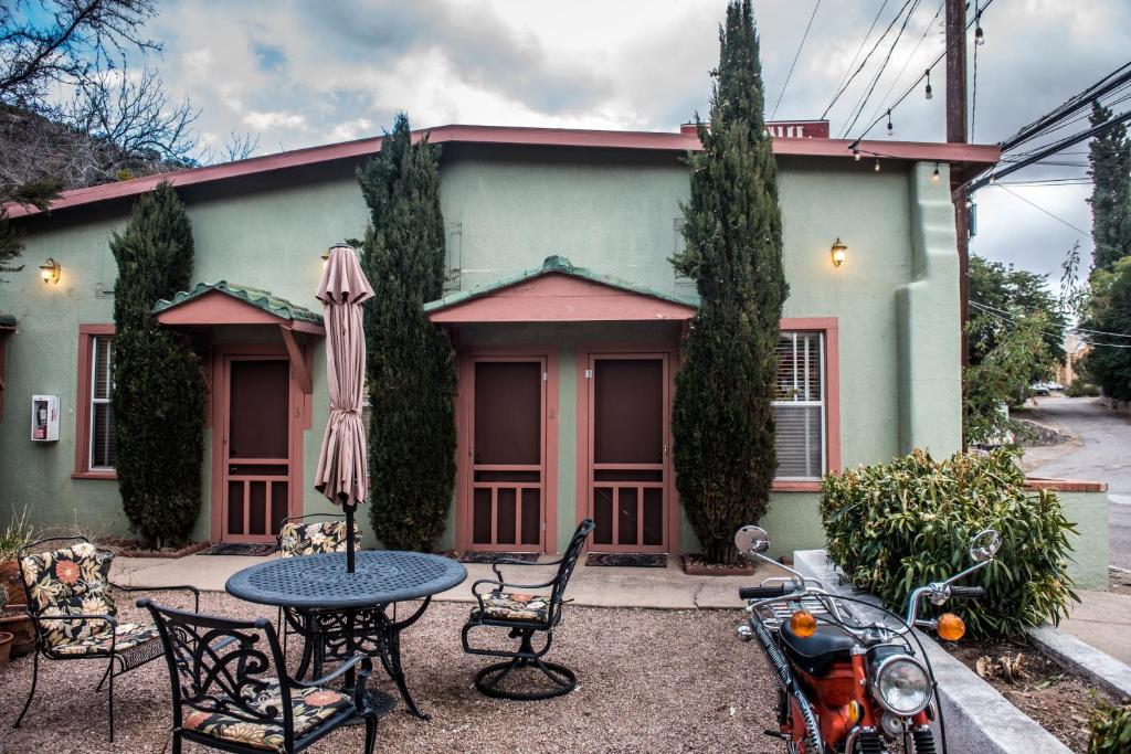 une maison avec une table, des chaises et un parasol dans l'établissement Jonquil Motel, à Bisbee