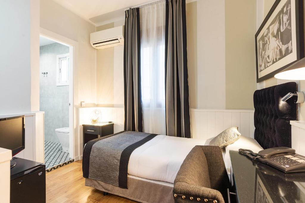a hotel room with a bed and a television at BYPILLOW California in Málaga