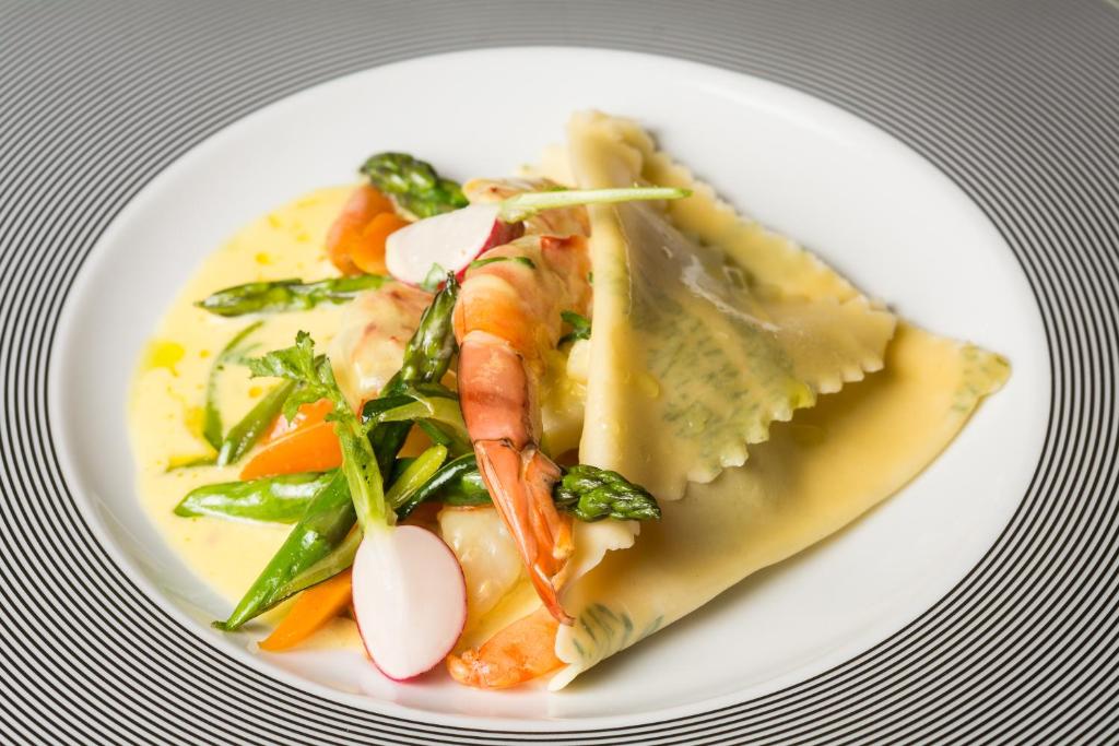 a white plate of food with shrimp and vegetables at Alchymist Grand Hotel and Spa - Preferred Hotels & Resorts in Prague