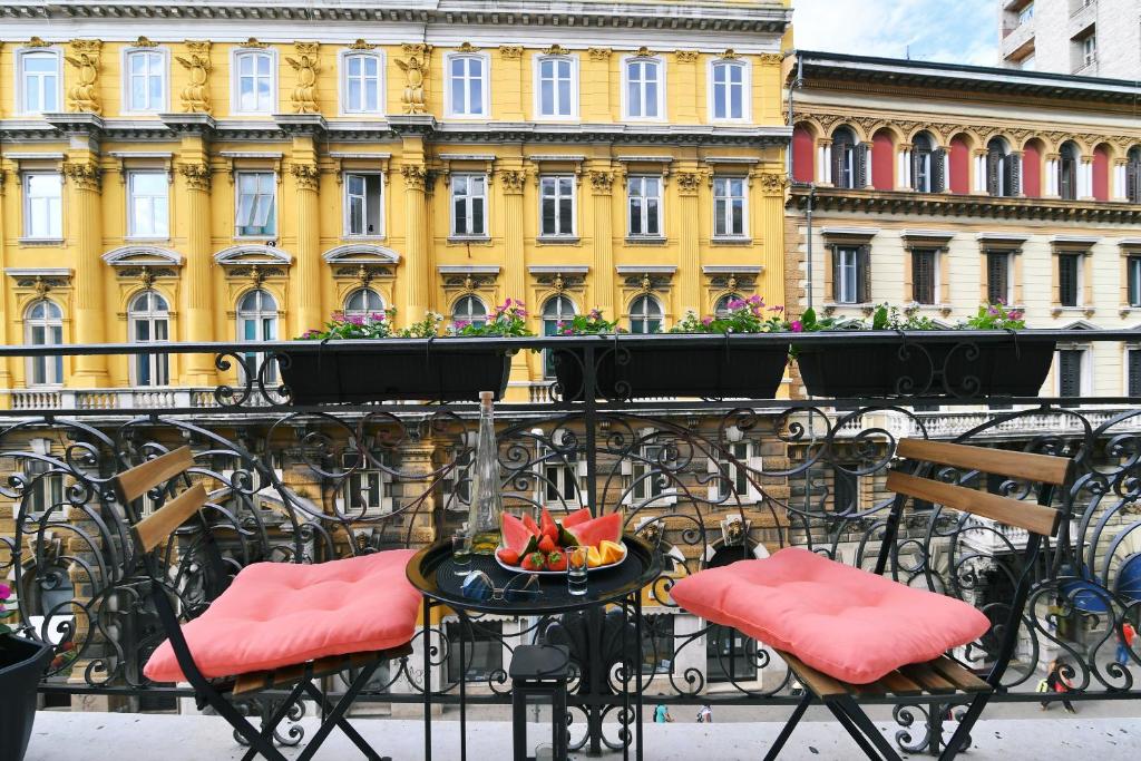 een balkon met een tafel en stoelen en een gebouw bij Vitopolis 1&2 in Rijeka