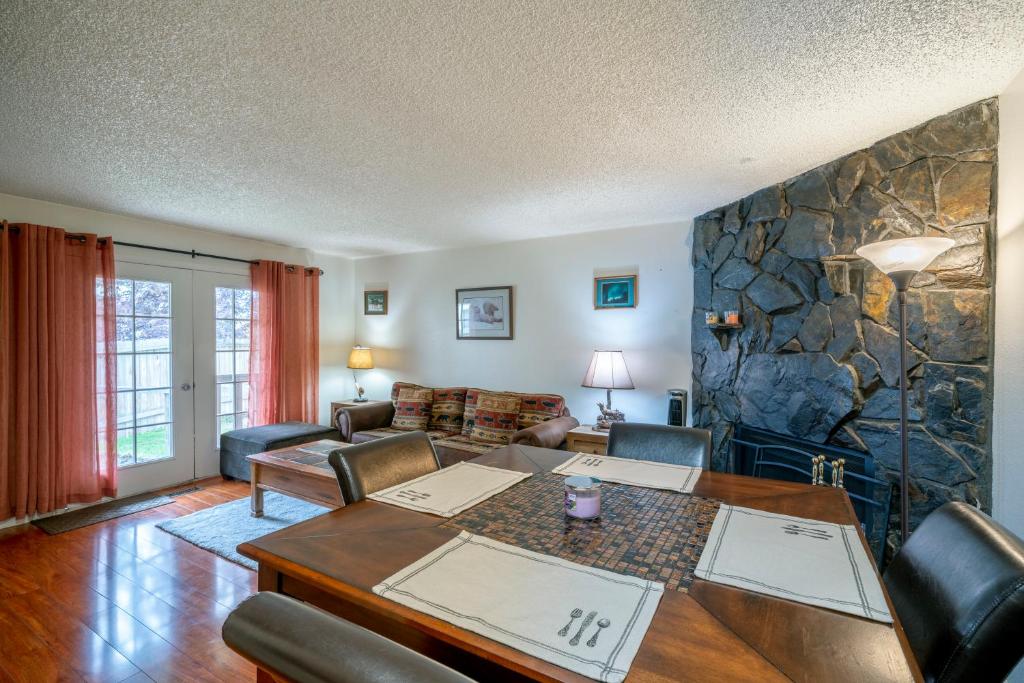 a living room with a table and a stone wall at Polar Bear Den in Anchorage